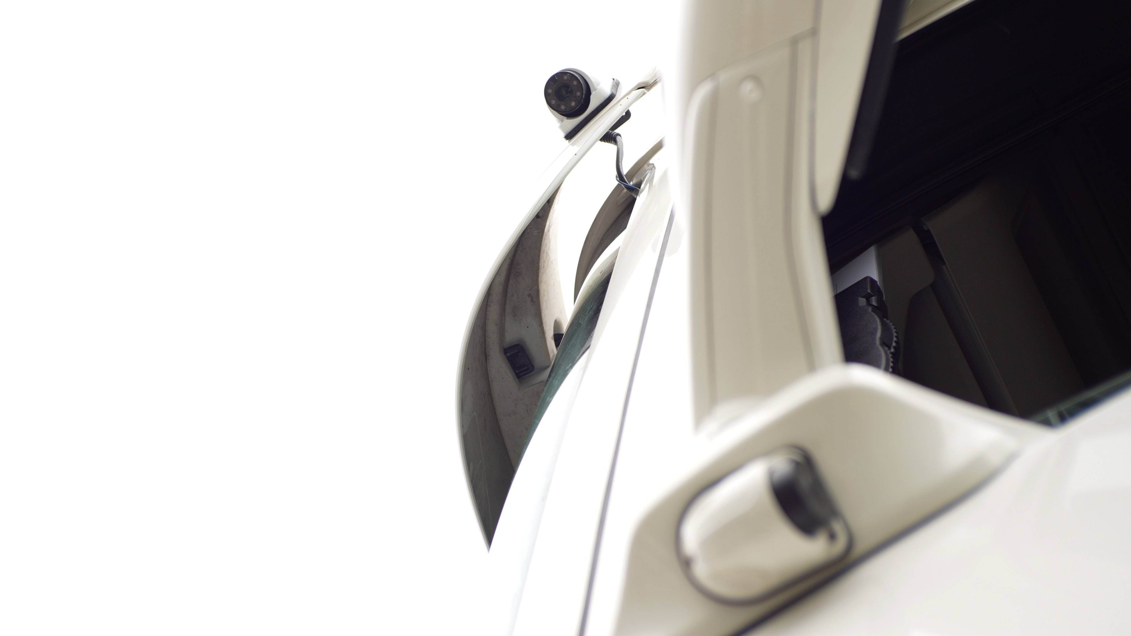 Nearside blind-spot camera mounted on a white commercial vehicle